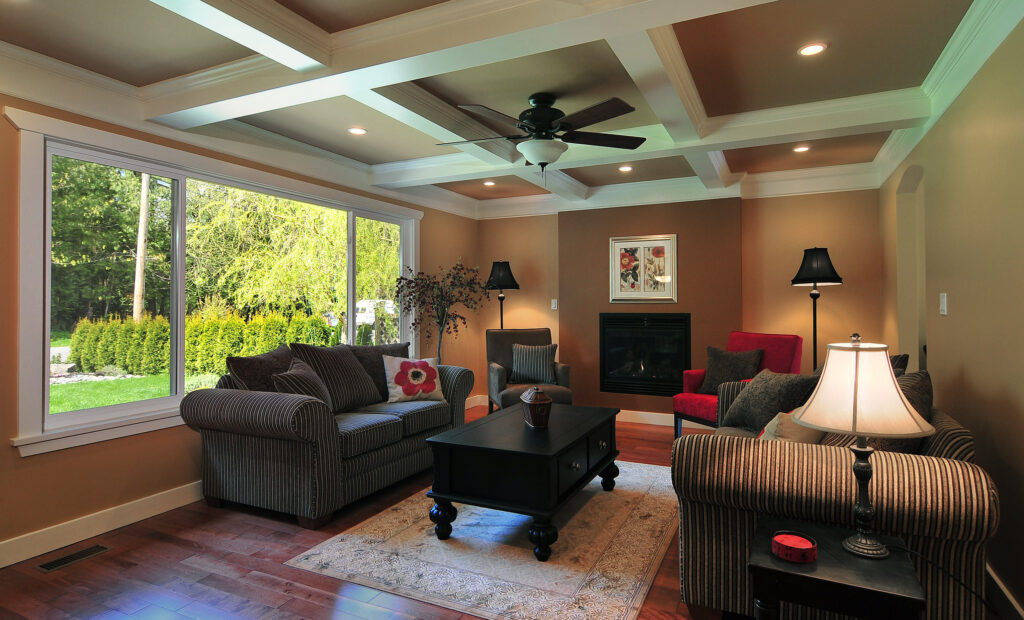 The picture demonstrates developed painting skills. The panels in the box beam ceiling are painted a feature color. The box beams are painted the trim color. The walls are painted the main color. The flush fireplace is painted a feature wall color.